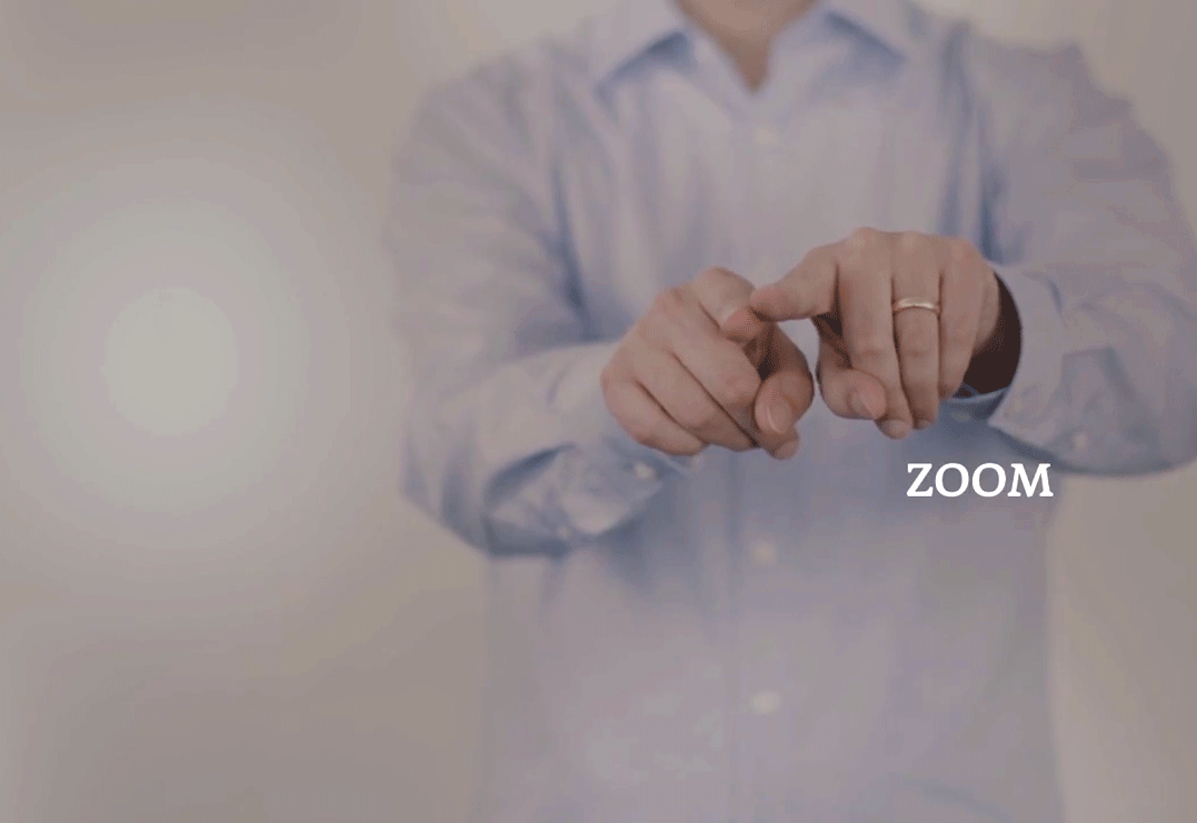 Kurzes Video einer Person in der unschärfe, die vor sich ausgestreckt mit den Händen die Geste "Zoom" vollführen.
